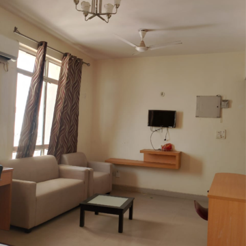 Living Room in Studio Apartment at Supertech Czar Suites, Omicron I Greater Noida – for Rent
