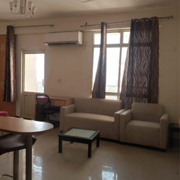 Living Room in Studio Apartment at Supertech Czar Suites, Omicron I Greater Noida – for Rent